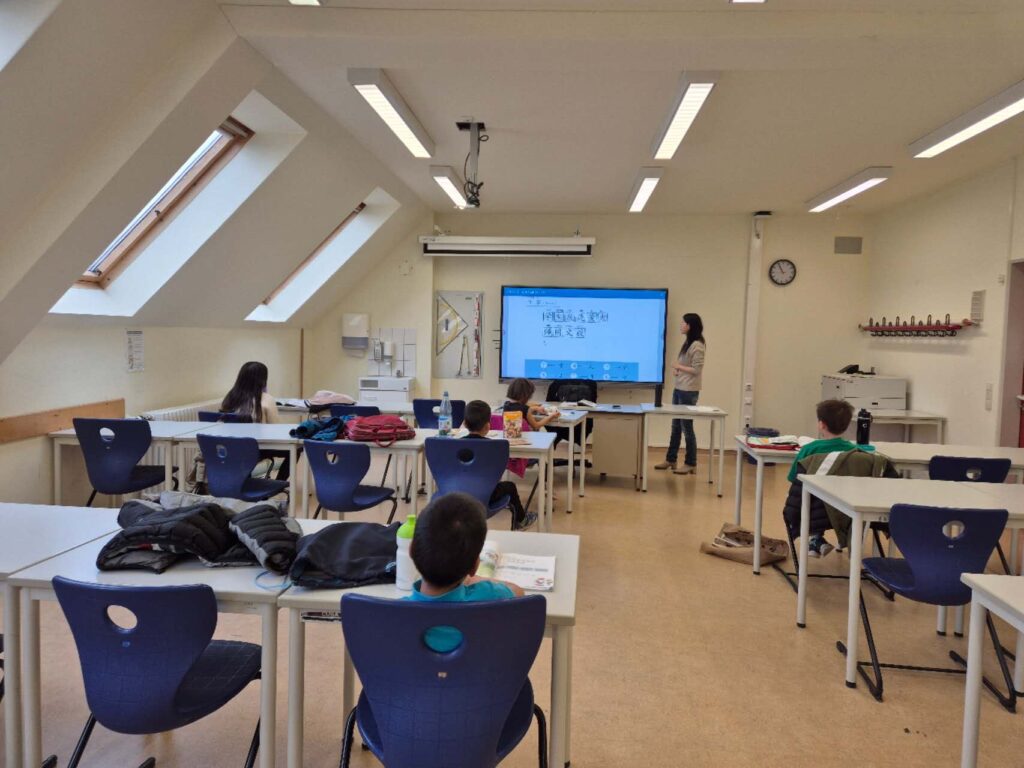 Unterrichtsraum der Sprachschule mit Kindern und Lehrerin