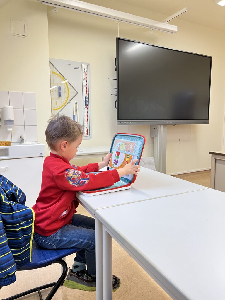 Junge mit einem Lernspiel im Klassenraum