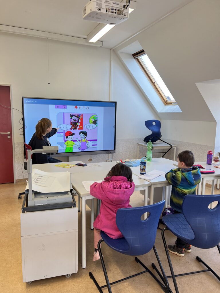 Lehrerin erklärt eine Lektion am interaktiven Bildschirm