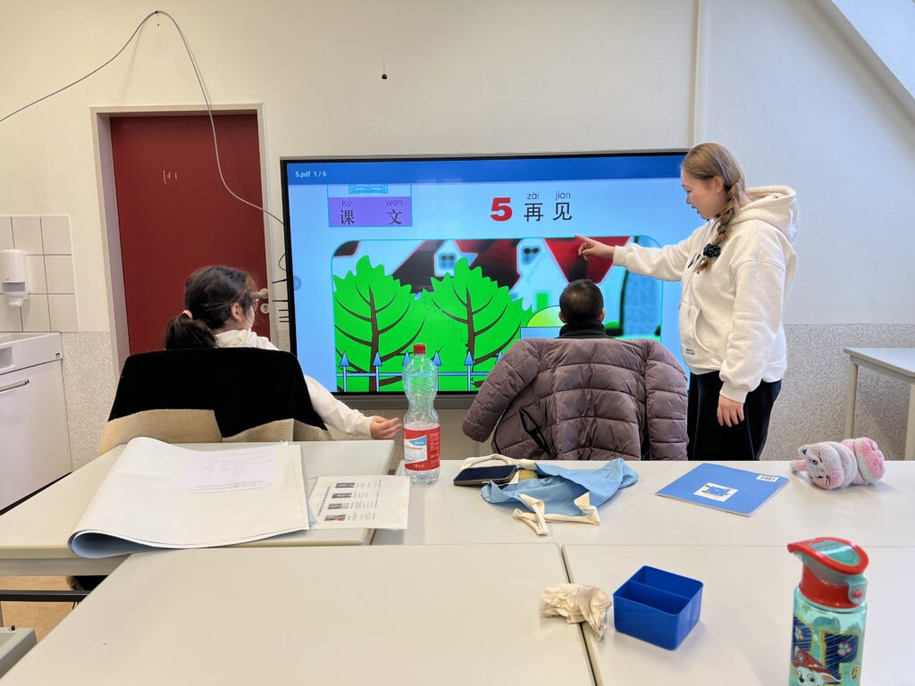 Lehrerin zeigt eine Lektion am interaktiven Bildschirm
